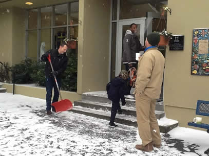 Parents Shovel Snow at School Entrance